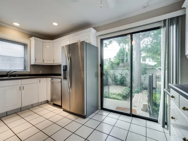a kitchen with a refrigerator and white cabinets