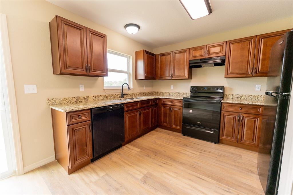 13060 Southwest 83rd Terrace Road Ocala, FL 34473 - Photo 22 of 42 a kitchen with stainless steel appliances granite countertop a sink stove and refrigerator
