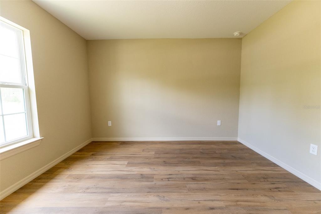 13060 Southwest 83rd Terrace Road Ocala, FL 34473 - Photo 32 of 42 a view of an empty room with wooden floor and a window