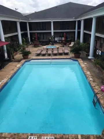 a view of a house with backyard patio and swimming pool