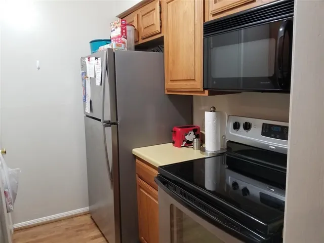 a kitchen with stainless steel appliances a refrigerator and a microwave