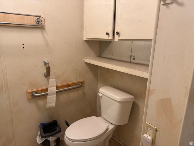 210 South State Street Moroni, UT 84646 - Photo 15 of 23 White toilet with a built-in shelf, two upper wall cabinets, and metal grab bars