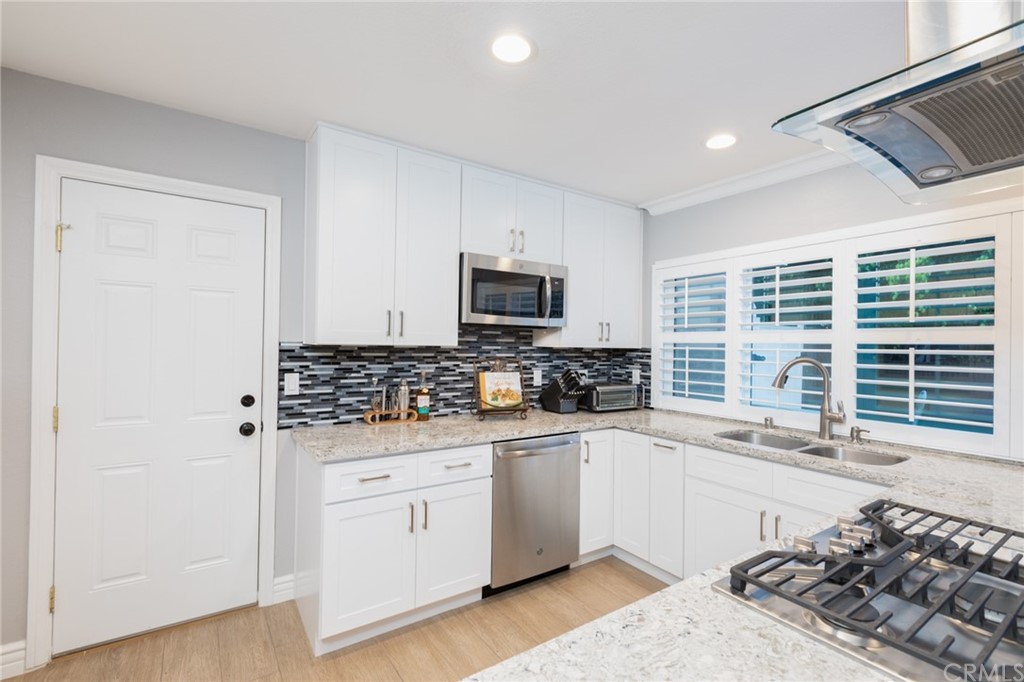 484 Traverse Drive Costa Mesa, CA 92626 - Photo 2 of 17 a kitchen with stainless steel appliances a stove top oven a sink a refrigerator and a window