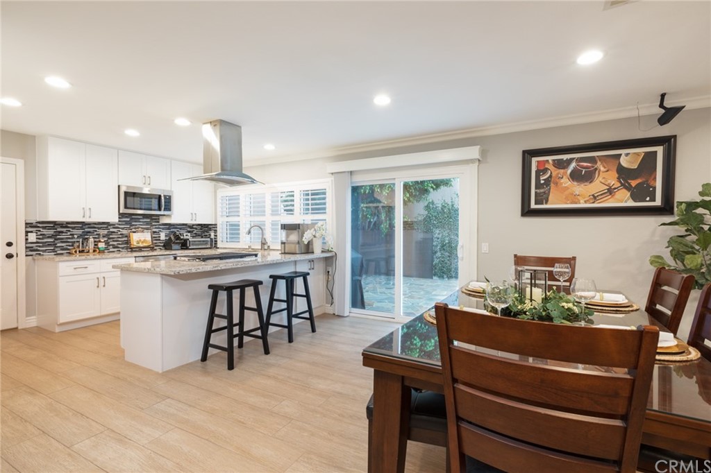 484 Traverse Drive Costa Mesa, CA 92626 - Photo 3 of 17 a kitchen with a table chairs refrigerator and cabinets