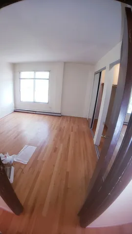 an empty room with wooden floor and closet