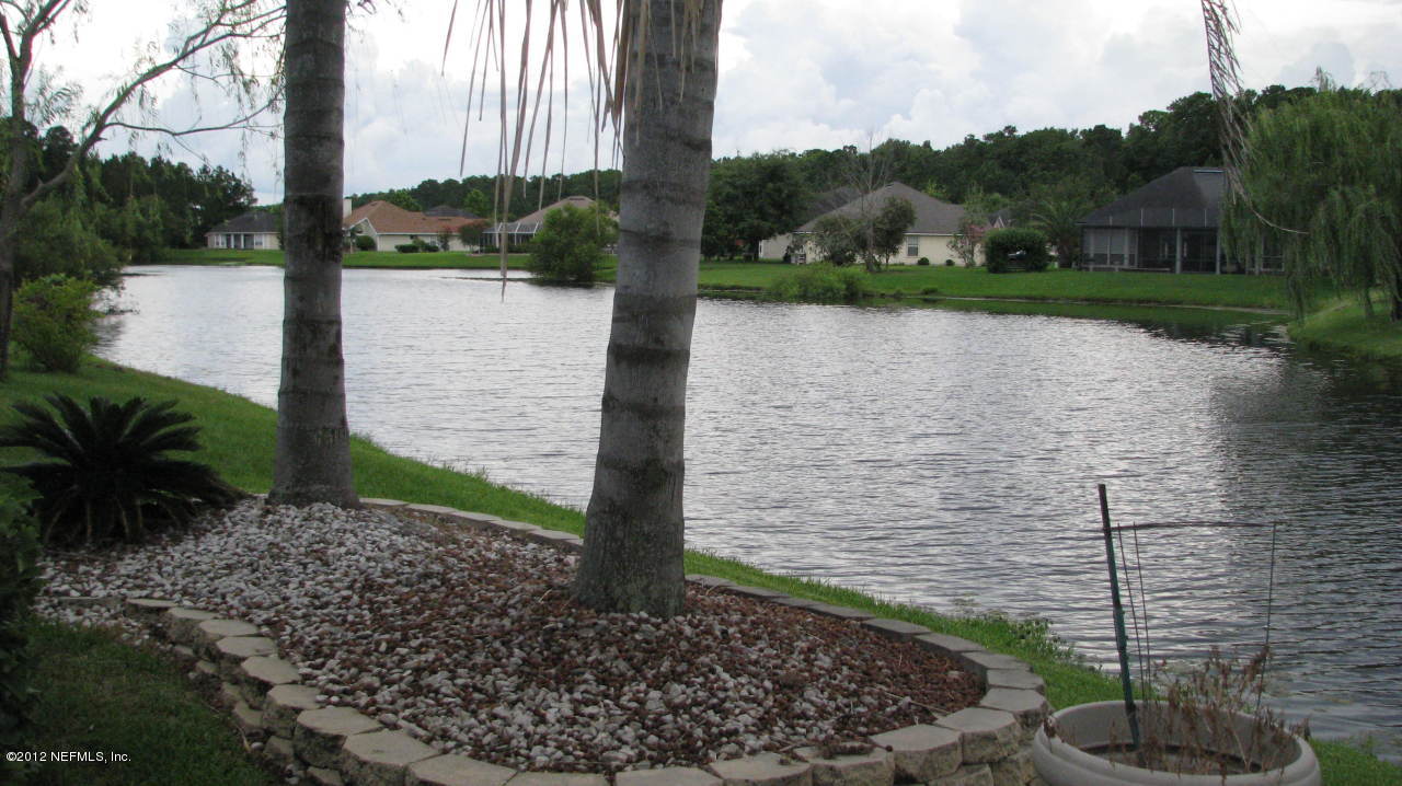 4152 East Ripken Jacksonville, FL 32224 - Photo 12 of 14 a view of a lake with a yard and large trees