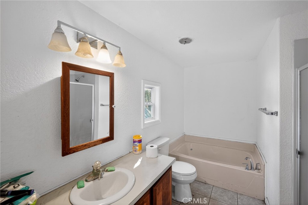 3804 Owl Creek Road Mariposa, CA 95338 - Photo 16 of 18 a bathroom with a granite countertop sink toilet and mirror