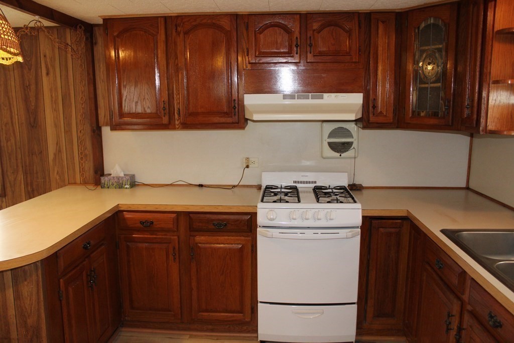 69 Mobile Home Way Springfield, MA 01119 - Photo 8 of 42 a kitchen with a stove top oven sink and cabinets