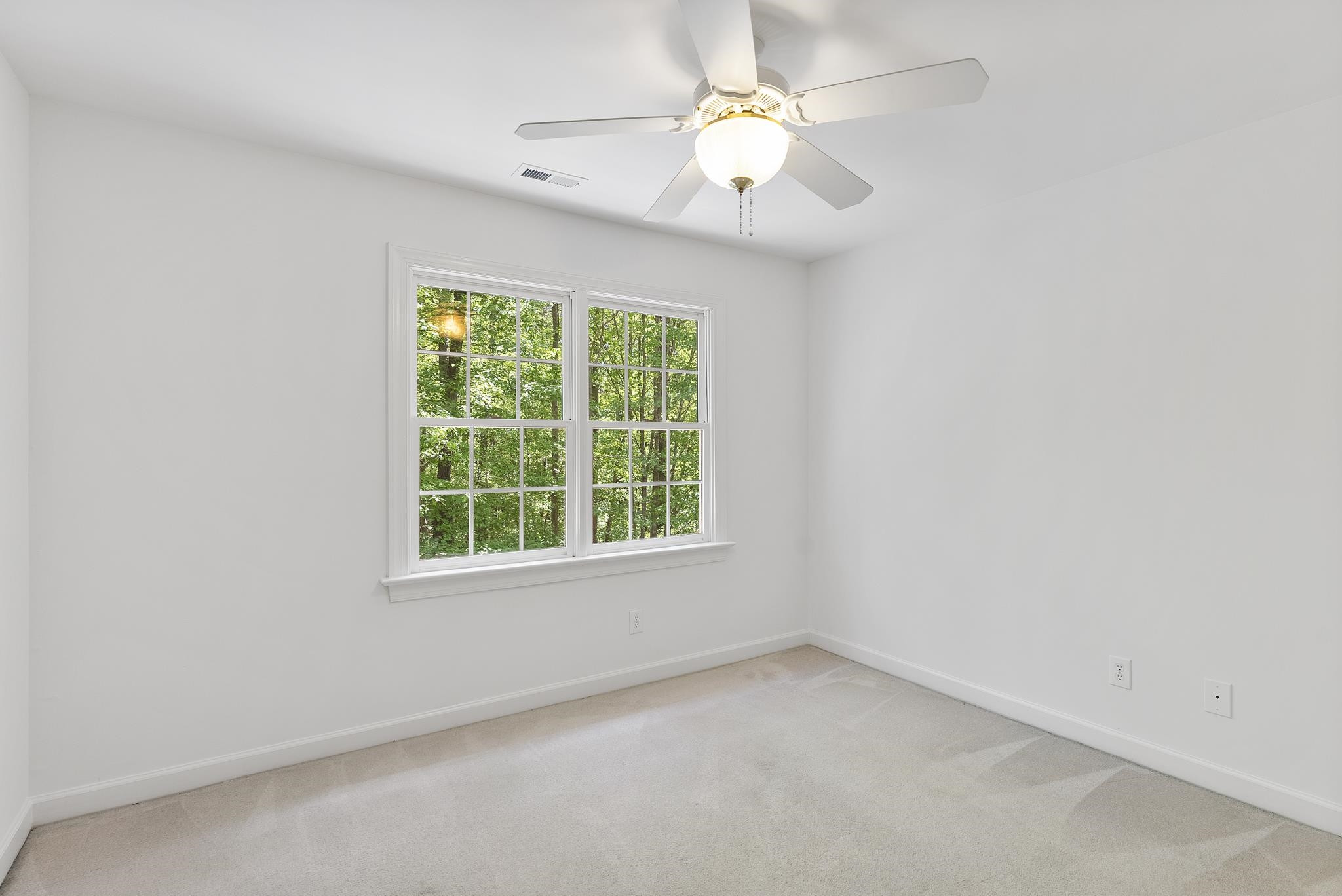 9436 Macon Road Raleigh, NC 27613 - Photo 22 of 37 an empty room with a window and a fan