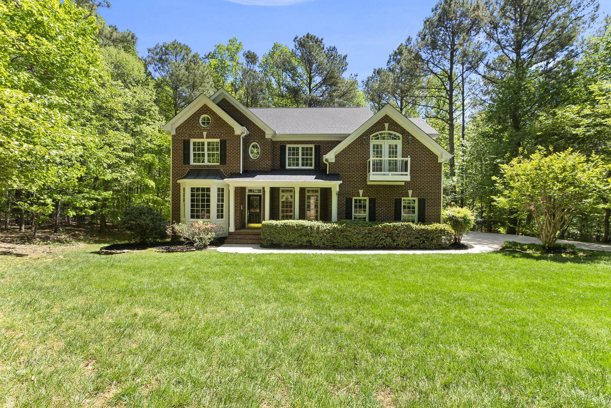 9436 Macon Road Raleigh, NC 27613 - Photo 3 of 37 a front view of a house with a yard and trees