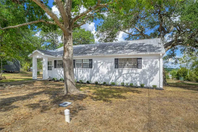 a front view of a house with a garden and yard