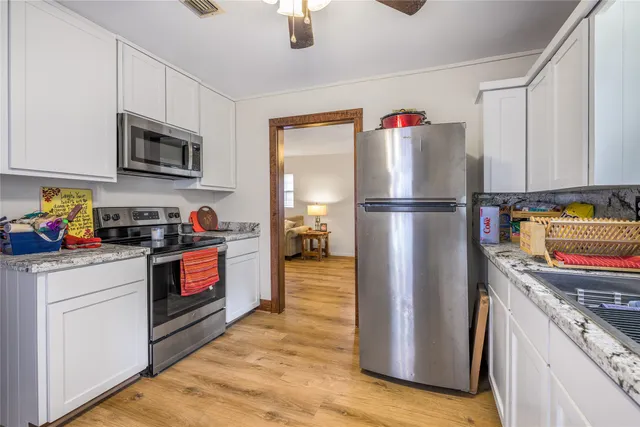 a kitchen with stainless steel appliances granite countertop a refrigerator sink and microwave