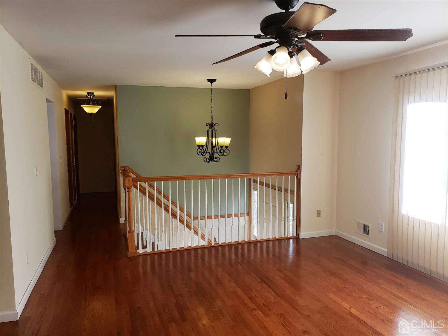 24 Hillsdale Road Edison, NJ 08820 - Photo 9 of 41 a view of a hallway with wooden floor and a chandelier