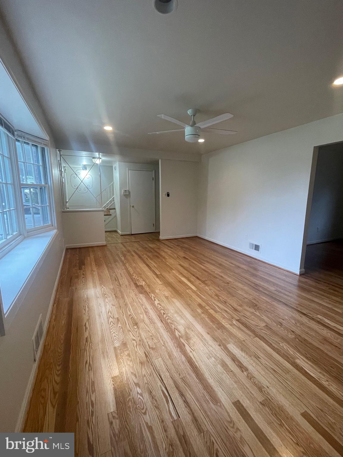 a view of an empty room with wooden floor