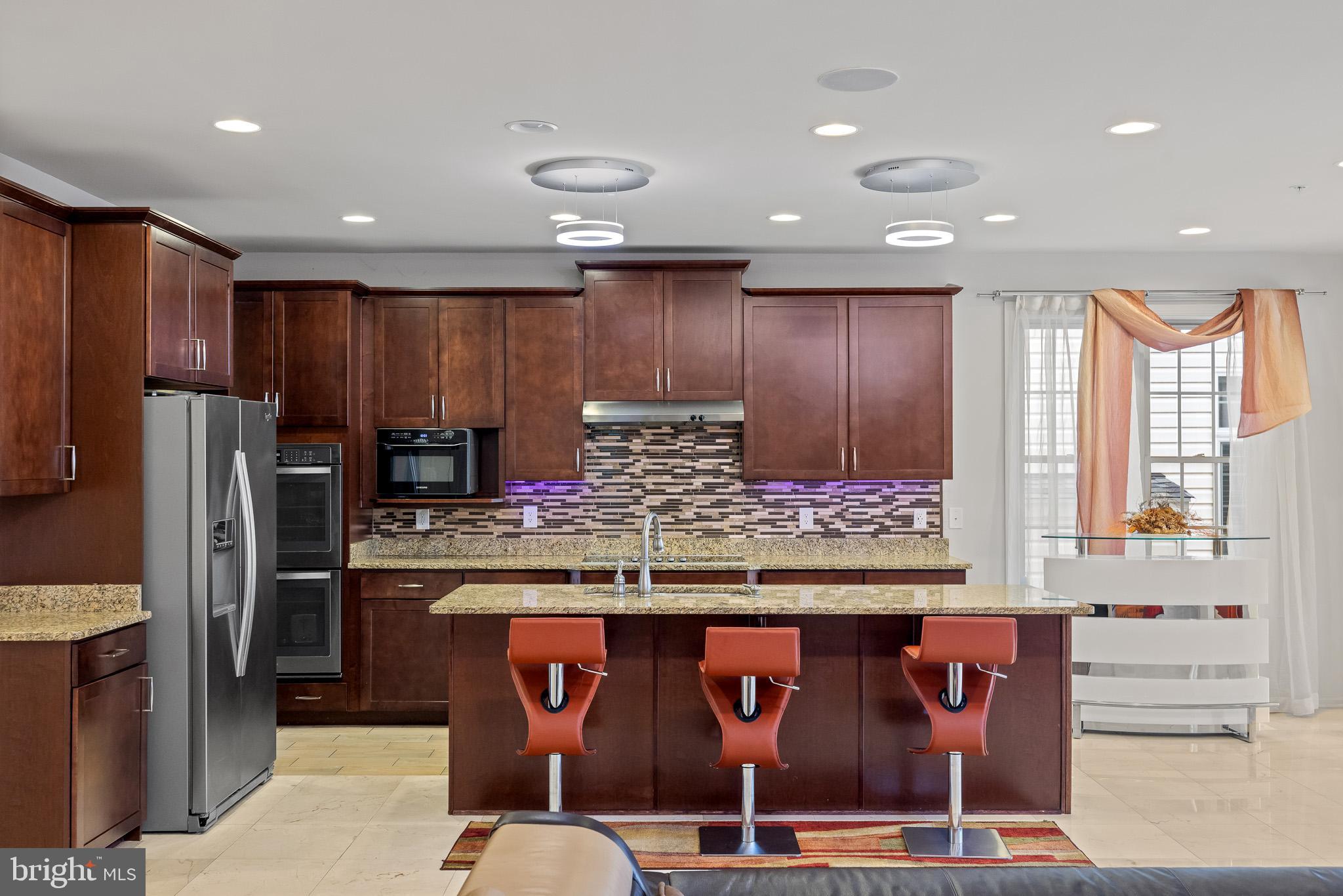 1116 Autumn Brook Avenue Silver Spring, MD 20906 - Photo 16 of 67 a kitchen with kitchen island granite countertop wooden cabinets a refrigerator and a stove