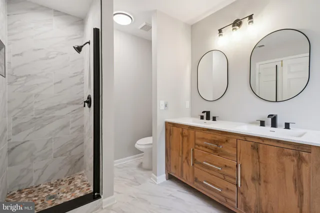 a bathroom with a double vanity sink mirror and toilet