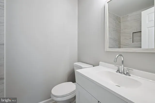 a bathroom with a sink a toilet and mirror