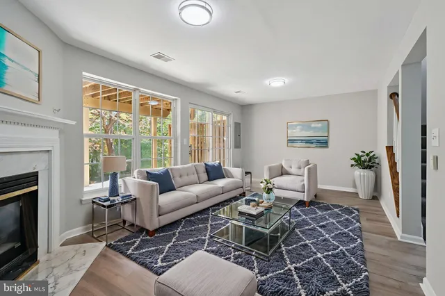 a living room with furniture a fireplace and a floor to ceiling window