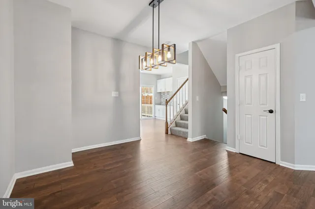 a view of a hallway with wooden floor and staircase