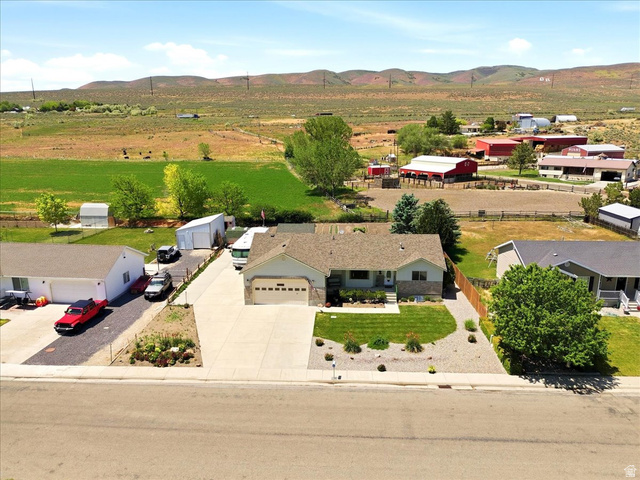 72 Canal Bank Road Garland, UT 84312 - Photo 40 of 40 Ranch-style residence featuring an attached two-car garage, concrete driveway, and a landscaped front yard with lawn and decorative rock
