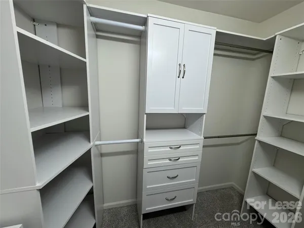 a view of walk in closet with empty racks