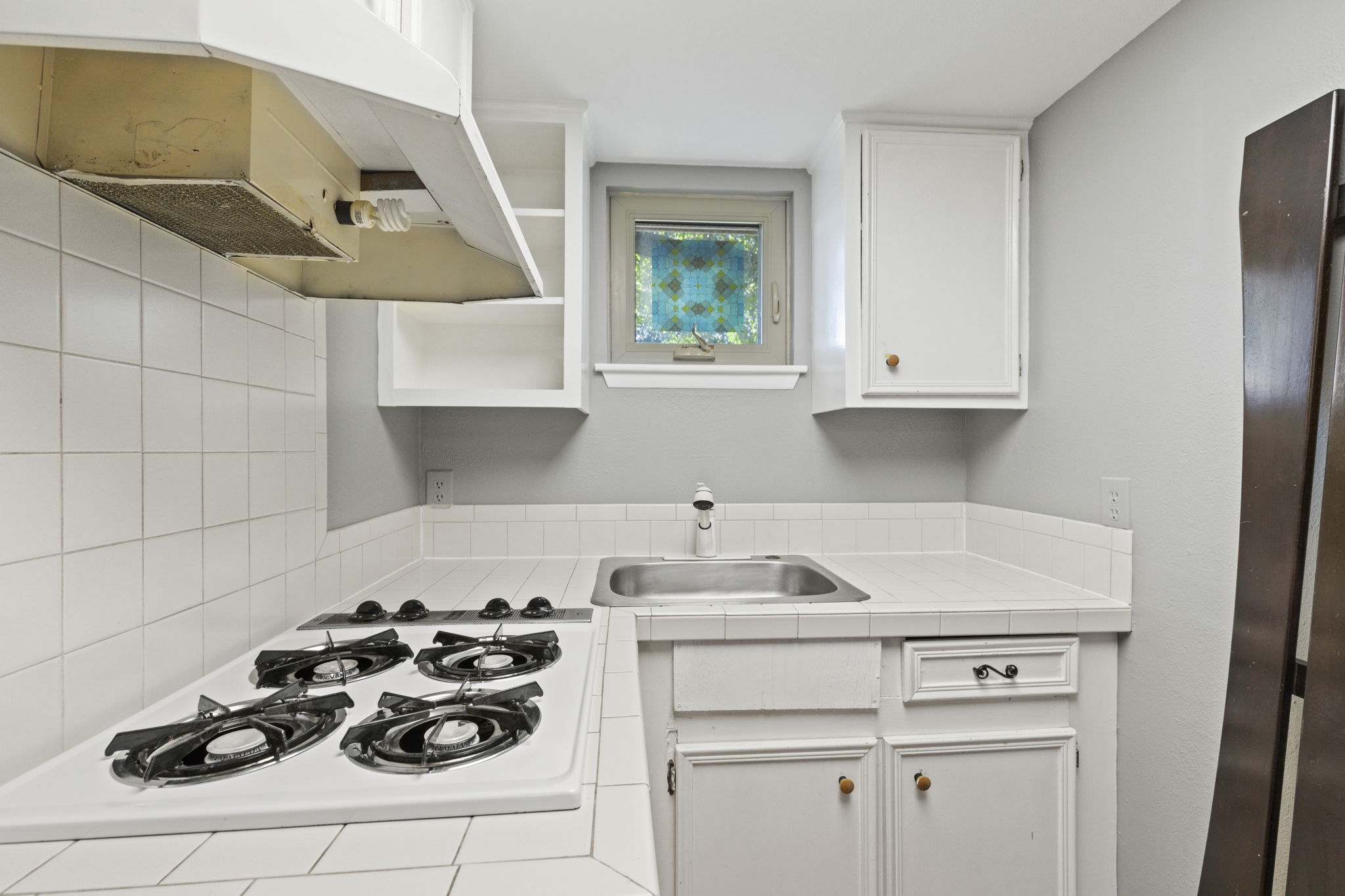 7808 Watson Street, Unit B Austin, TX 78757 - Photo 9 of 12 a kitchen with a sink stove and white cabinets