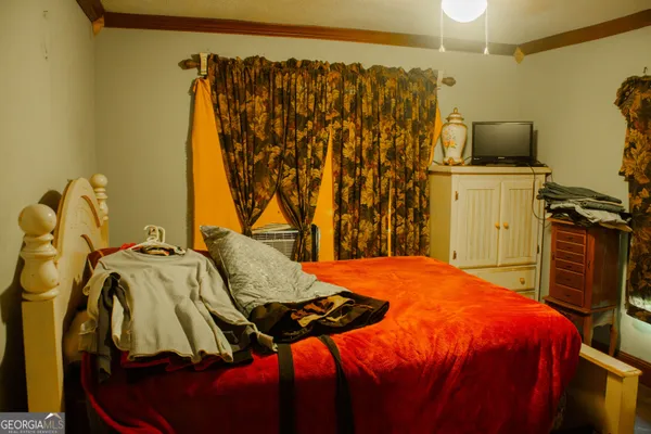 a bedroom with a bed and a flat tv screen