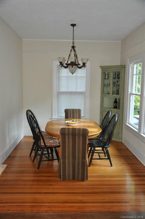 5423 Park Road Charlotte, NC 28209 - Photo 5 of 13 a dining room with furniture wooden floor a rug and a chandelier