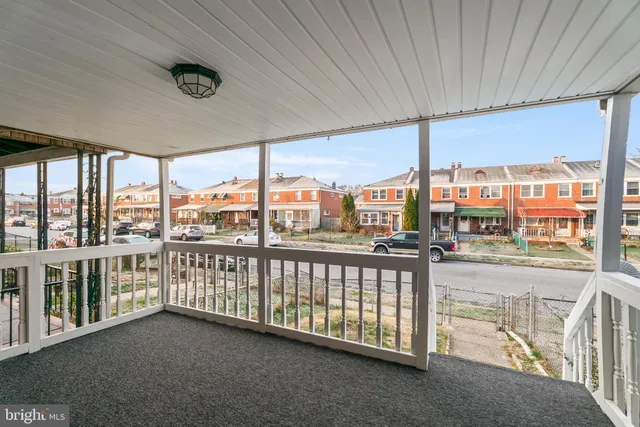 a view of an empty room with wooden floor and a ceiling fan