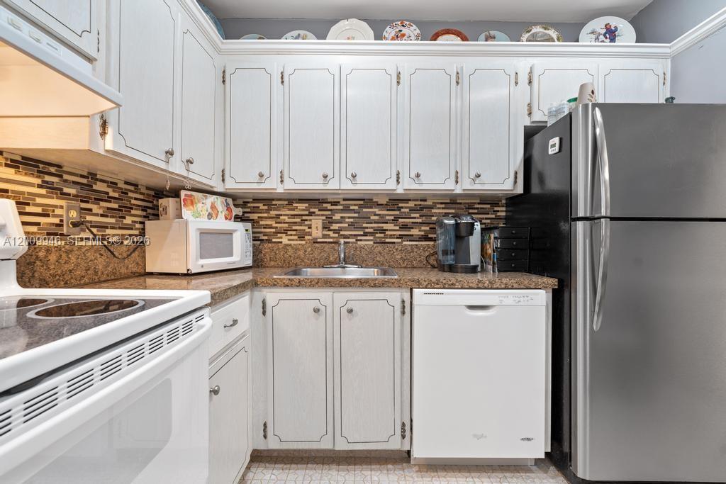 400 South Cypress Road, Unit 424 Pompano Beach, FL 33060 - Photo 12 of 29 a kitchen with appliances a sink and cabinets