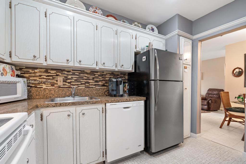 400 South Cypress Road, Unit 424 Pompano Beach, FL 33060 - Photo 24 of 29 a kitchen with granite countertop cabinets and refrigerator