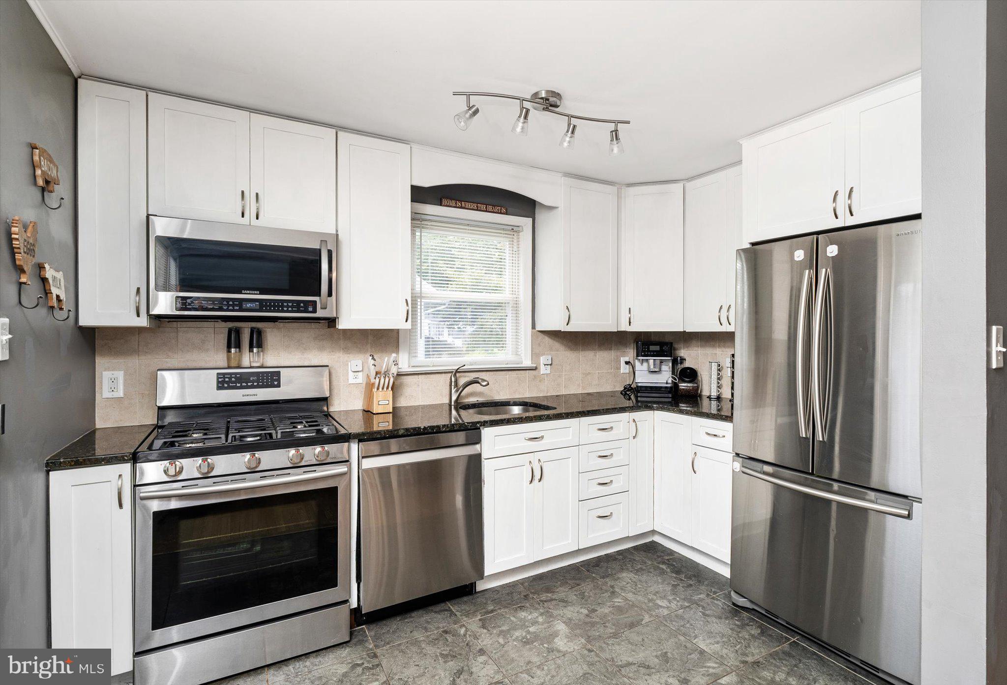 25 Holt Circle Hamilton, NJ 08619 - Photo 9 of 29 a kitchen with stainless steel appliances white cabinets white stove a microwave and a refrigerator
