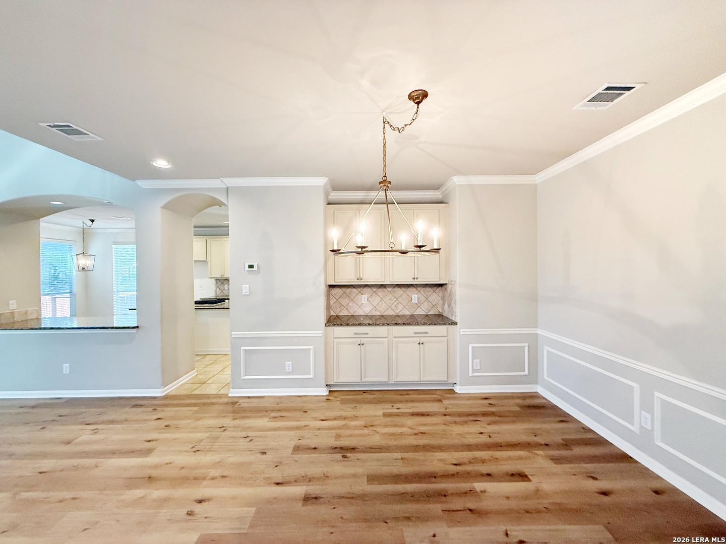 16015 Ponderosa Pth Helotes, TX 78023 - Photo 6 of 49 a view of empty room with wooden floor and kitchen view
