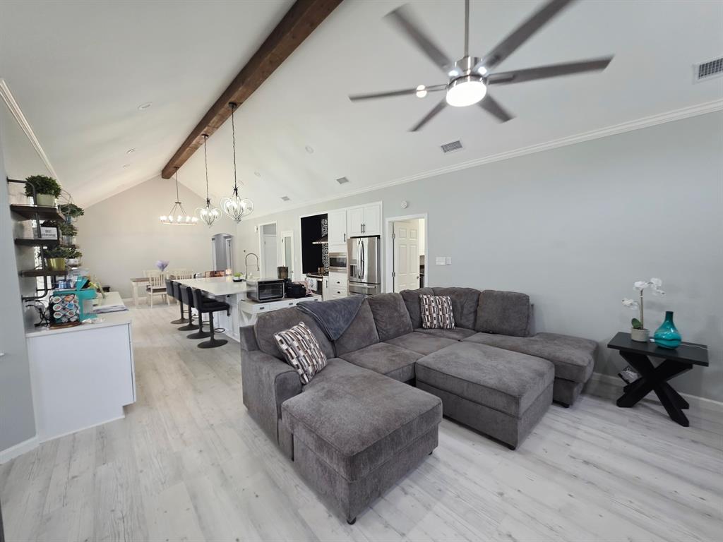 520 Red River Road Belton, TX 76513 - Photo 27 of 36 Vaulted ceilings with an exposed wood beam detail, complemented by wood-finish flooring throughout the space