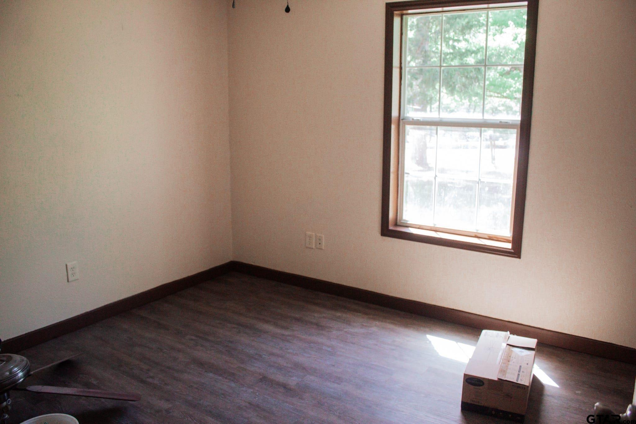 185 Caroline Street Rusk, TX 75785 - Photo 7 of 14 an empty room with wooden floor and windows