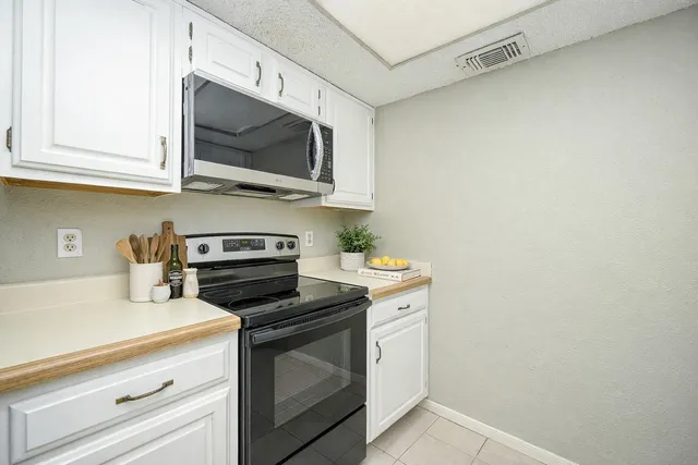 a kitchen with stainless steel appliances a stove a microwave and cabinets