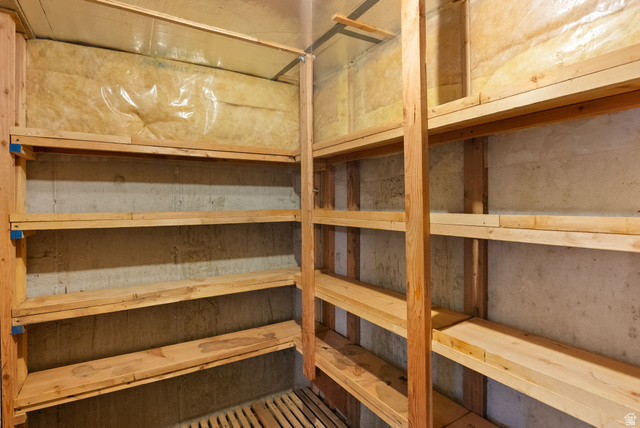 435 Canyon Road Millville, UT 84326 - Photo 47 of 113 Dedicated storage room featuring extensive wood shelving, concrete walls, and visible insulation