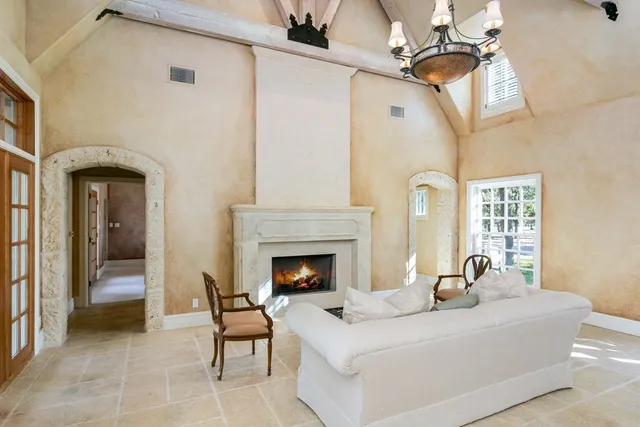 a living room with furniture a fireplace and a chandelier