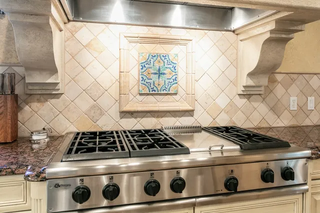 a stove sitting inside of a kitchen with white cabinets
