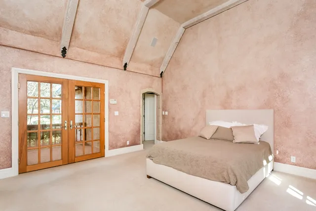 a spacious bedroom with a large bed and a large window