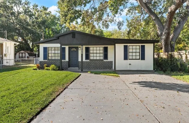 a front view of a house with a yard and trees