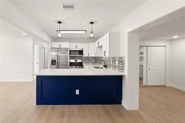 a kitchen with kitchen island sink stove and refrigerator