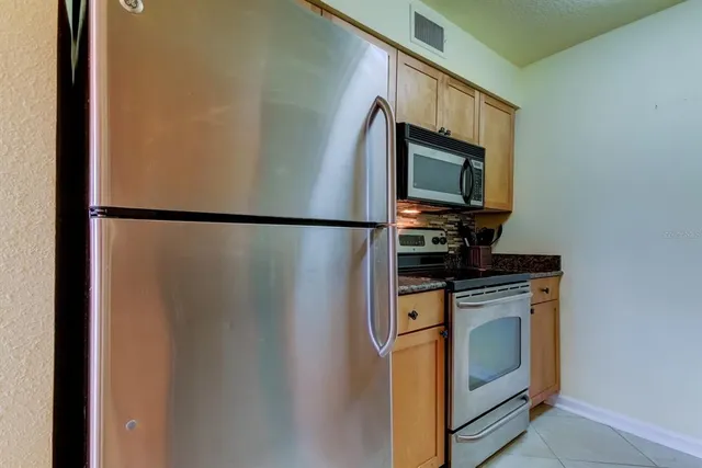 a view of a kitchen with a sink and a refrigerator
