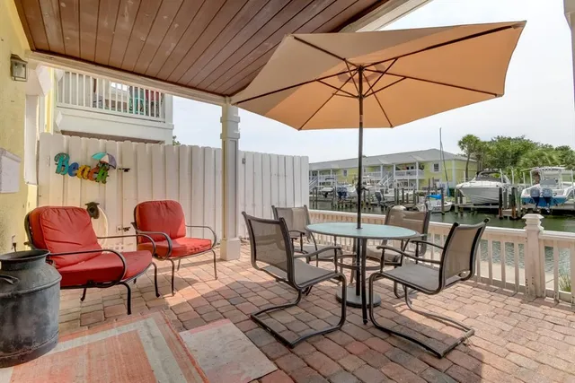 a view of a patio with table and chairs under an umbrella