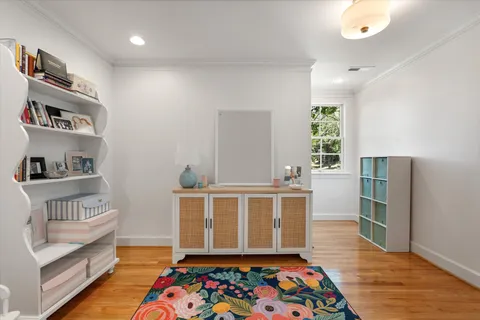 a spacious bedroom with a bed a large window with table and chair