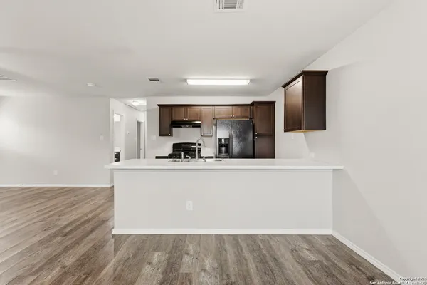 a view of kitchen with sink microwave and refrigerator
