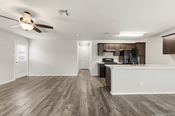 an empty room with a window and a fan