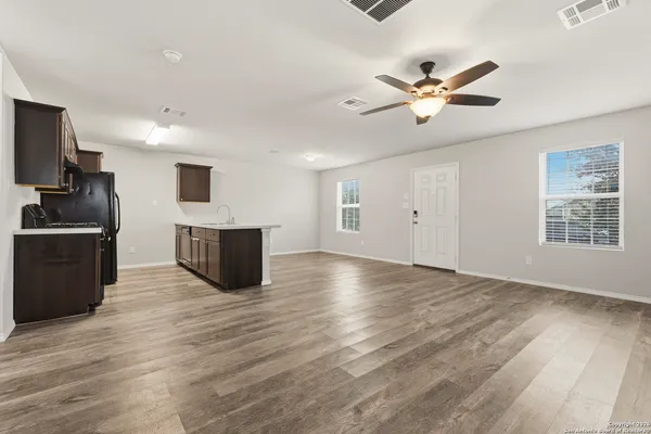 a living room with hard wood floors and a kitchen