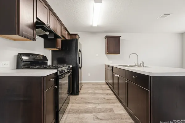 a kitchen with a sink and a stove top oven