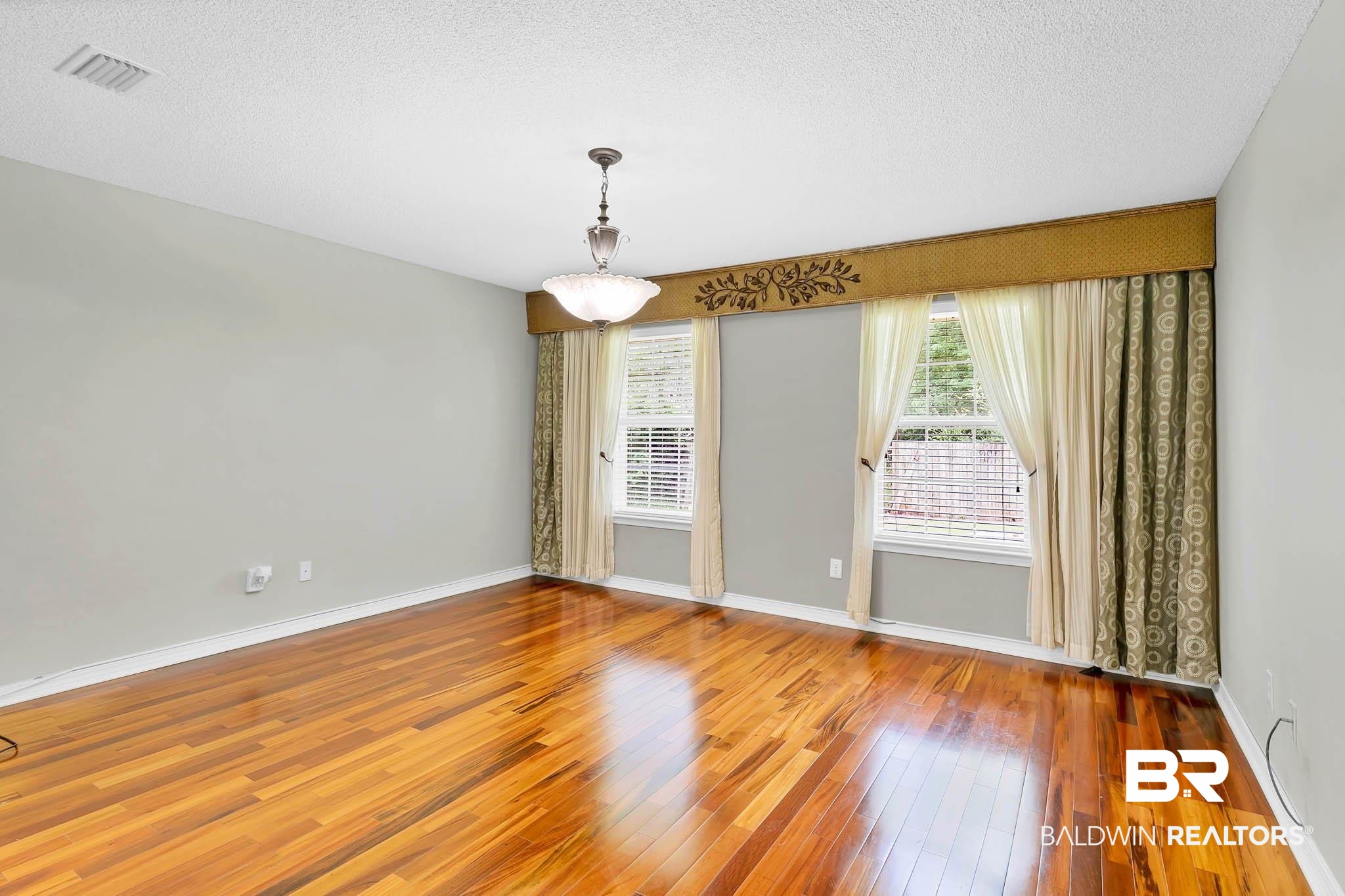 329 Collinwood Loop Foley, AL 36535 - Photo 18 of 35 Spare room with hardwood / wood-style flooring, baseboards, and a textured ceiling